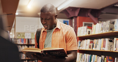 Buy stock photo Black student, reading and book as man in library for research, studying and exam preparation. Person, novel and literature information for knowledge, education and language assessment at university