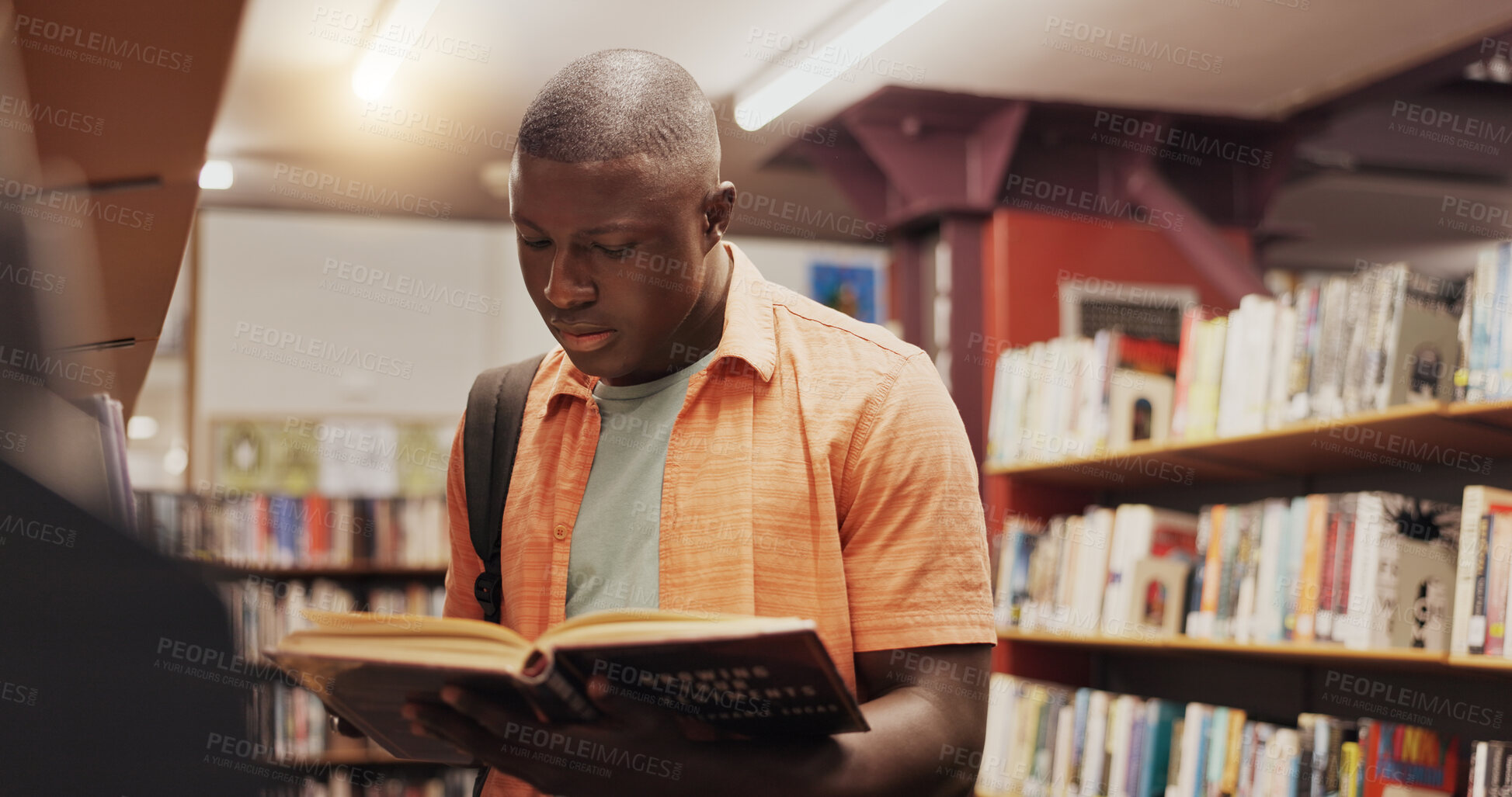 Buy stock photo Black student, reading and book as man in library for research, studying and exam preparation. Person, novel and literature information for knowledge, education and language assessment at university