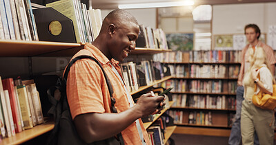 Buy stock photo Learning, phone and student man in library to search for books or study material. App, education and social media scrolling with happy person on college or university campus for school scholarship
