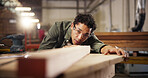Man, carpenter or wood with plank on workbench for polish, craft or timber project at workshop. Male person, woodworker or safety glasses for wooden repair, lumber restoration or design at warehouse