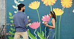 Couple, painting and creative wall with art project, mural design and advice for renovation process. Happy, people and artist with hobby of community improvement, diy decoration and flowers aesthetic
