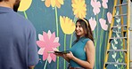 Woman, smile and painting in city for wall art, creative mural and project to uplift community. People, team creativity and outdoor with happy for floral design, volunteer collaboration and DIY hobby