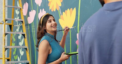 Buy stock photo Woman, happy and painting in city for wall art, creative mural and project to uplift community. People, team creativity and outdoor with smile for floral design, volunteer collaboration and DIY hobby