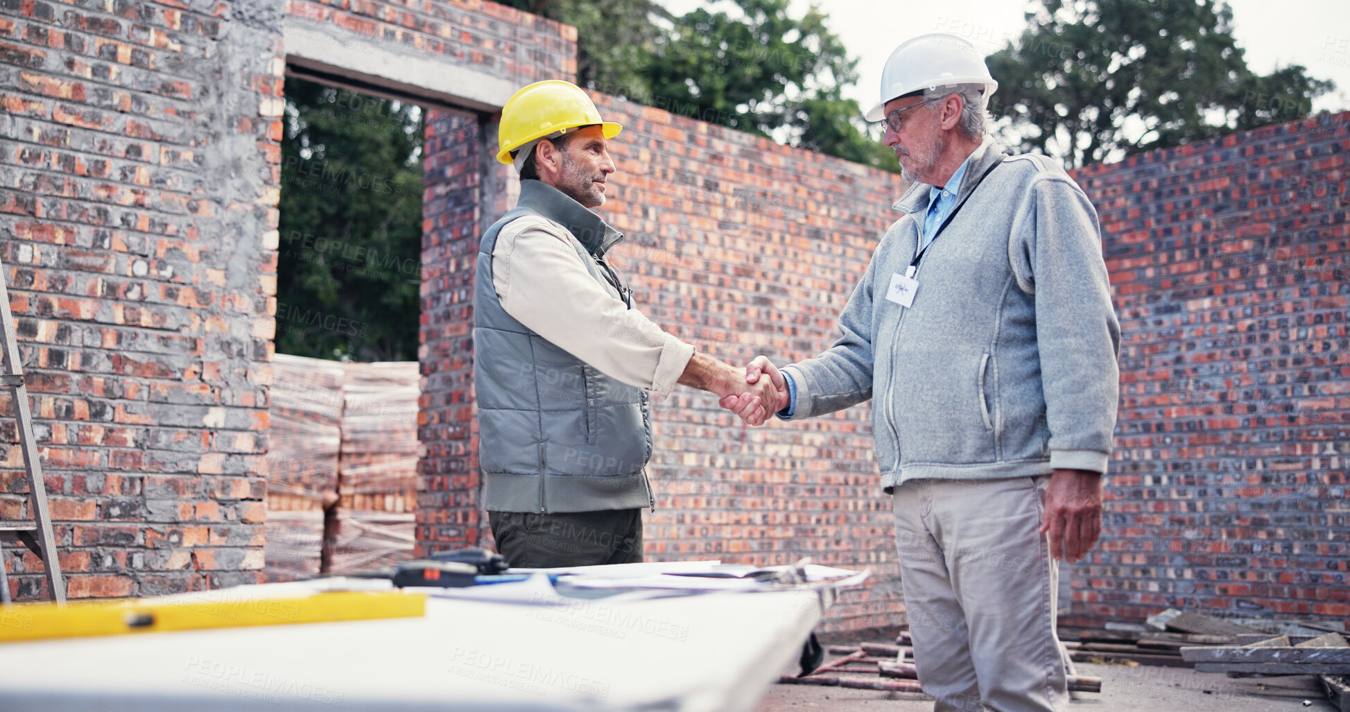 Buy stock photo Meeting, handshake and people on construction site for plan, inspection or collaboration at table. Contractor, welcome and men with partnership for blueprint, brainstorming or architect design