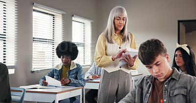 Buy stock photo Test, high school and teacher in classroom with paper, exam and assignment for education. Woman educator, teenage students and quiz notes in academy for learning, growth assessment and development