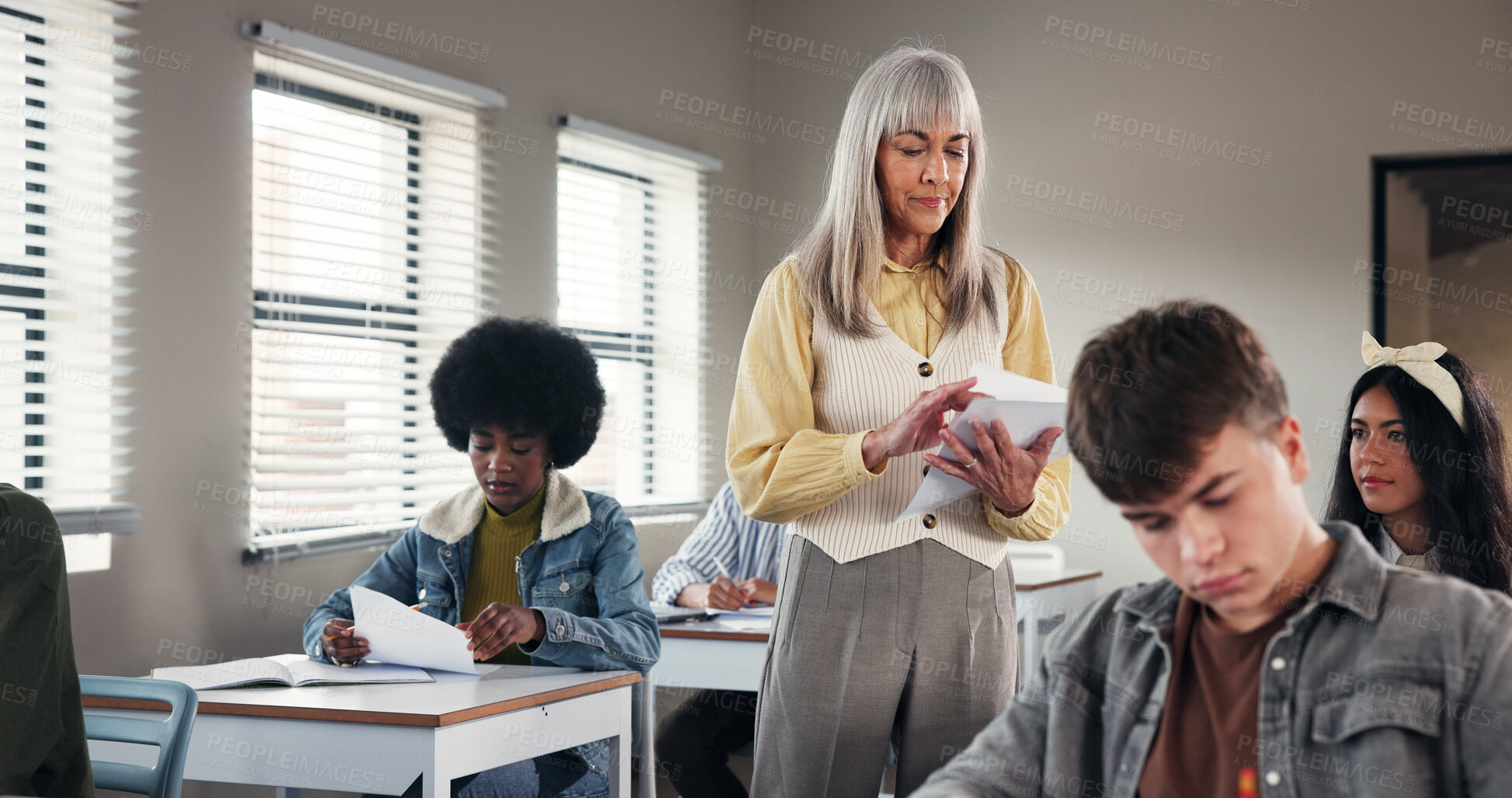 Buy stock photo Test, high school and teacher in classroom with paper, exam and assignment for education. Woman educator, teenage students and quiz notes in academy for learning, growth assessment and development