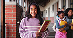 Portrait, school and girl with book, students and smile with education, child development and growth. Face, group and children with knowledge, diversity and confidence with pride and scholarship 