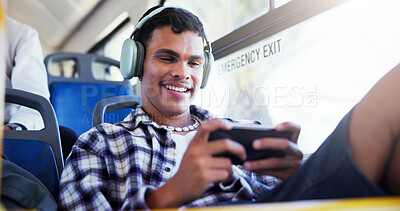 Buy stock photo Happy man, phone or playing with headphones on bus for travel, local commute or entertainment. Male person, traveler or mobile gamer with smile for online streaming app or network in public transport