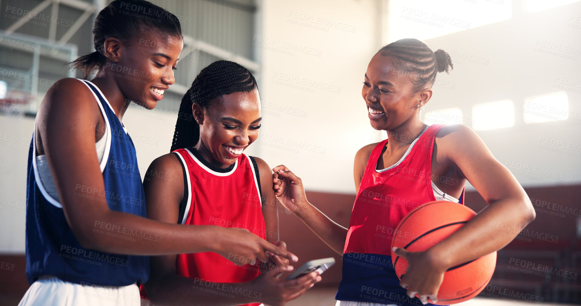 Buy stock photo Sports, team and girls with smartphone, basketball and watching game on social media, group or laughing. Fun, player and black people with mobile for videos, smile and scroll on web for entertainment