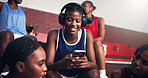 Phone, smile and headphones with black woman on basketball court for sports progress, athlete scouting and streaming. Score tracking, training program and subscription with person and game updates
