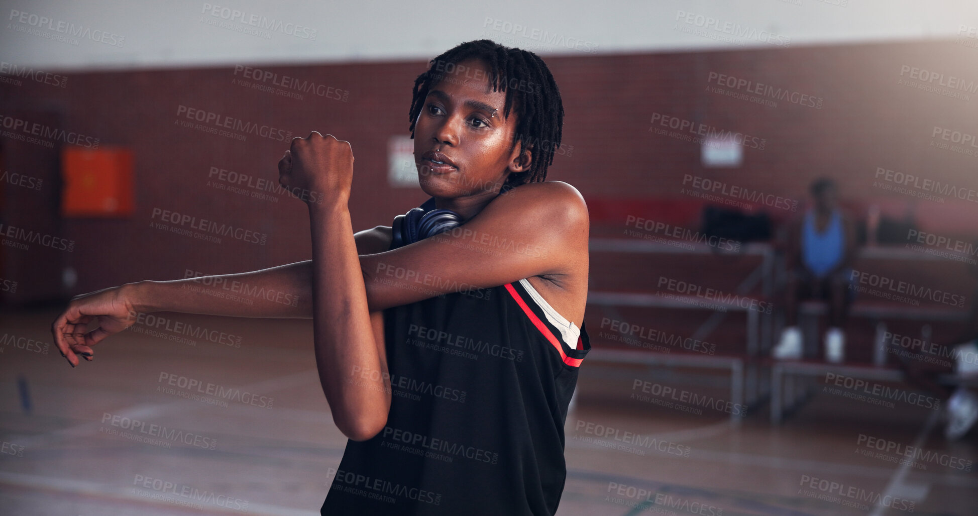 Buy stock photo Basketball, workout and girl with stretching on court for match preparation, tournament exercise and training. Sport, black woman and arm warm up for game wellness, fitness practice and getting ready