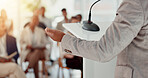 Businessperson, microphone or hand of speaker in seminar for education, event or presentation. Conference, leader or corporate coach with forum speech on podium for public relations or development