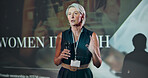 Business, speech and woman at seminar at stage for motivation at tech conference. Convention, talk and keynote speaker at event for training, coaching and inspiration with mature developer with mic