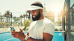 Man, phone and texting at tennis court for sport, smile or contact on break for training in summer. African person, athlete and smartphone on mobile app, happy or social media with fitness in Kenya