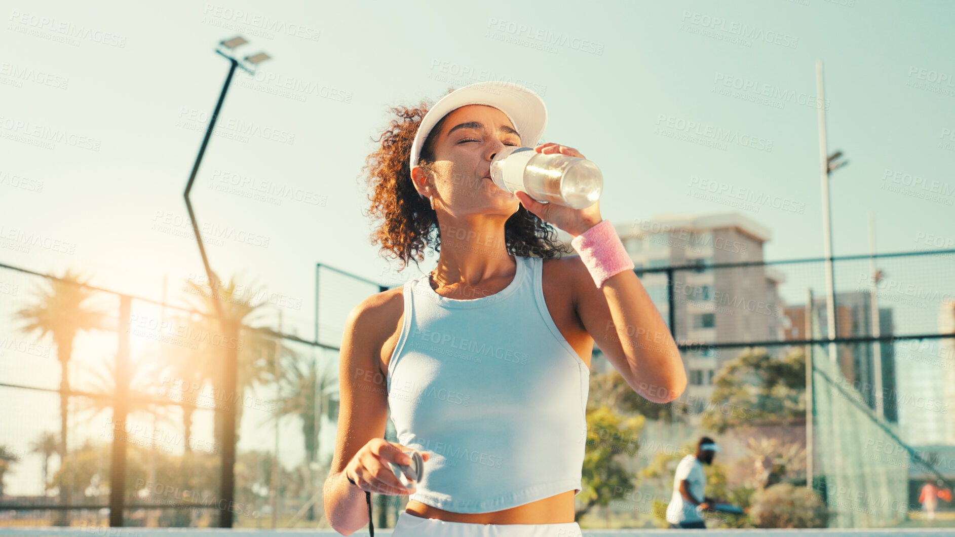 Buy stock photo Sports, drinking water and woman on outdoor tennis court for hydration, thirst and wellness on break. Fitness, athlete and person with bottle after training, exercise and workout for padel practice