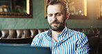 Laptop, small business and typing with man in coffee shop for blogging, planning or research online. Computer, internet and startup with freelance employee in cafe or restaurant for remote work