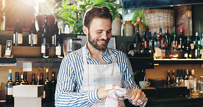 Buy stock photo Man, bartender and cleaning glass with cloth for hygiene, dust and service for drinks at restaurant. Person, waiter and check for dirt with smile, shine and career with inspection at small business