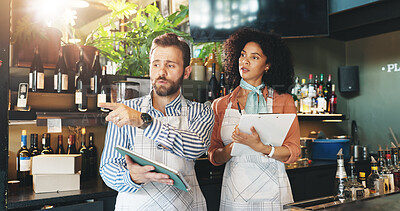 Buy stock photo Talking, small business and people with tablet, bar and discussion for inventory, pointing or clipboard. Collaboration, woman and man with tech for sales, serious or colleagues with app in restaurant