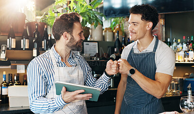 Buy stock photo Waiter, team and tablet in cafe with fist bump, positive online review or happy for order increase. Service industry, men or tech in restaurant for digital menu, alcohol or excited for shift list