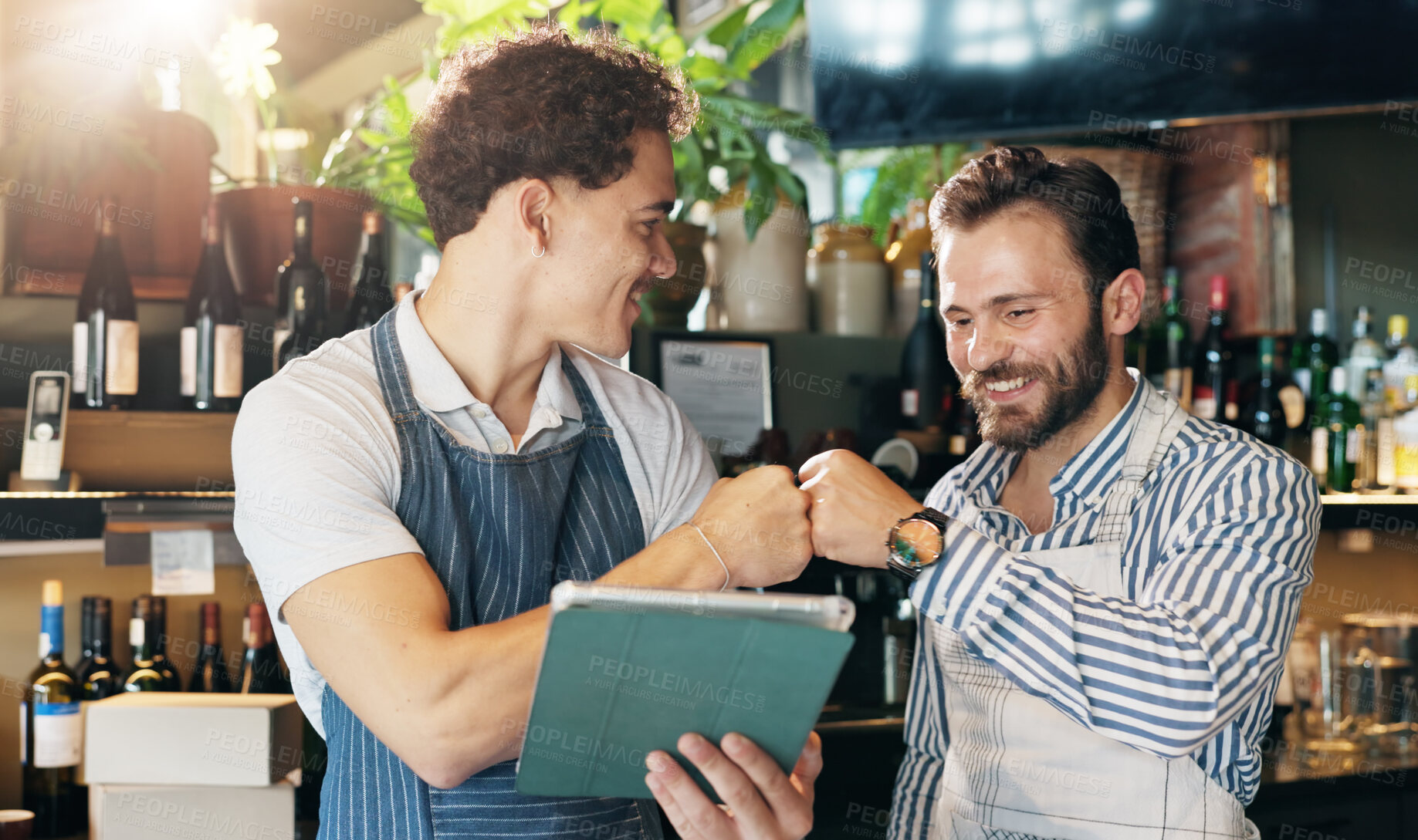 Buy stock photo Waiter, team and tablet in restaurant with fist bump, positive online review and happy for order increase. Service industry, men or tech in bar for digital menu, hospitality or excited for shift list