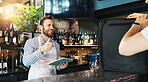 Man, tablet and courier for delivery at restaurant with smile for courier service, food or sale at diner. People, server or happy waiter with thumbs up, order or bag in meal with small business owner