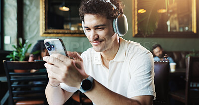 Buy stock photo Headphones, smartphone and man in cafe, relax and online for video, music and connection. Person, customer and mobile user in coffee shop, cellphone and headset for streaming, sound and app for audio