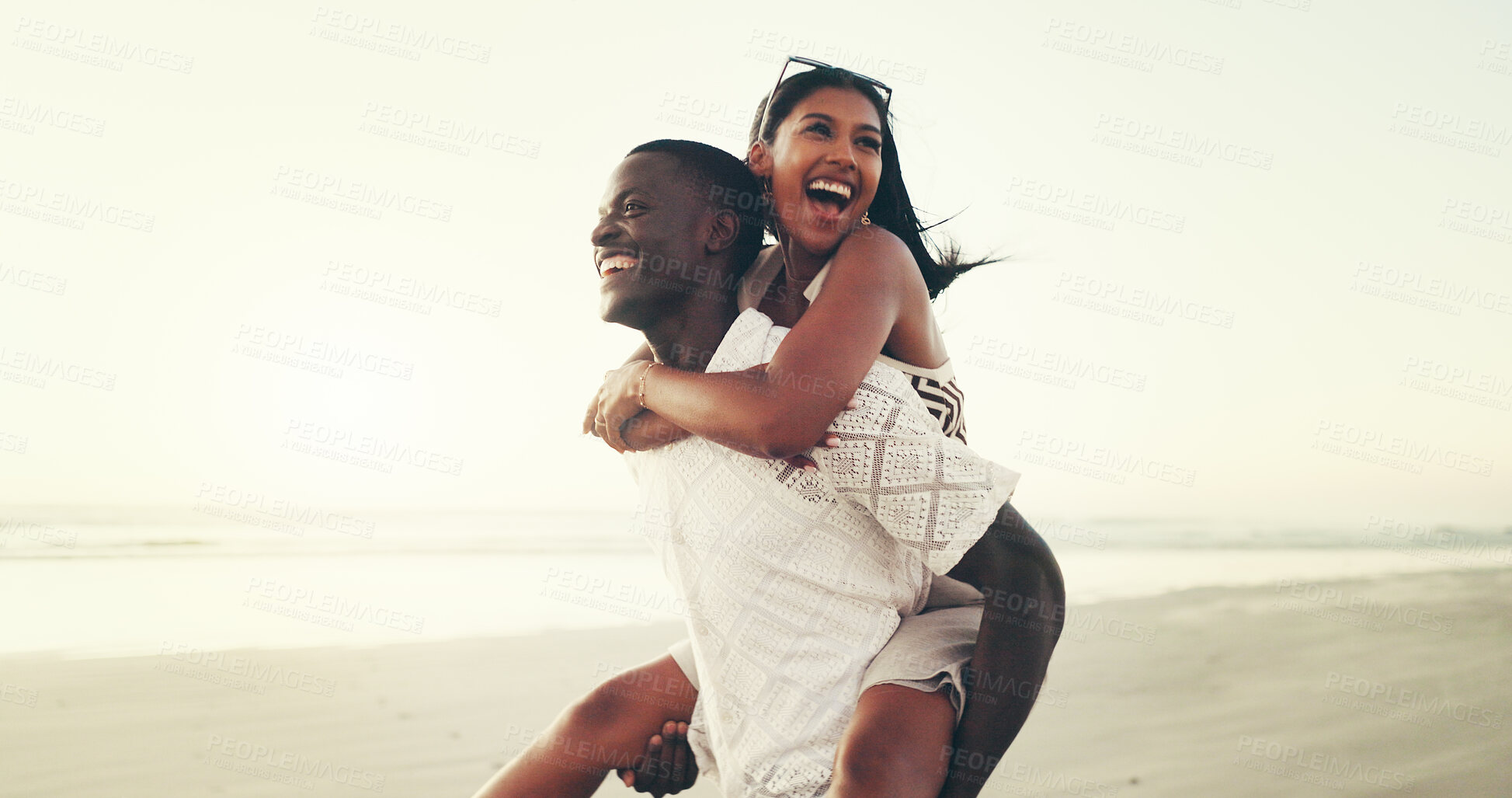 Buy stock photo Happy, interracial couple and fun piggyback on beach for summer trip, playful date and bonding. Space, people and laugh and travel for tropical vacation, support and relationship commitment at ocean