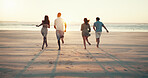 Running, sunset and back of friends on beach for tropical vacation, break or holiday together. Freedom, energy and group of people by ocean for seaside weekend trip for travel with activity in summer