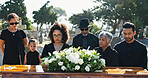 Sad, family and coffin at cemetery for funeral ceremony, burial service and loss outdoor with flower bouquet. Graveyard, death and people at casket for grief, mourning and respect with generations