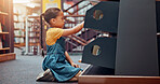 Shelf, search and child with books in library for reading story, literature and learning. School, bookstore and girl on floor with decision or choice for knowledge, education and language development