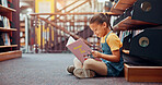 Girl, kid and reading book in school, relax and smile with fantasy, information and learning. Academic growth, student and child development with education, storytelling and novel with vocabulary