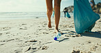 Legs, plastic bottle and volunteer at beach for pollution, bag and accountability with dirt in environment. Person, waste and feet with trash, rubbish and garbage on earth day by ocean in summer