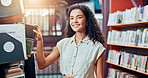 Woman, student and portrait by bookshelf at library, reading or happy with studying for scholarship at academy. Person, education and smile for literature, research or project for learning at college