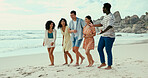 Beach, bonding and smile with friends walking on sand together for holiday, travel or vacation. Diversity, laughing and weekend with group of happy people outdoor on tropical island paradise
