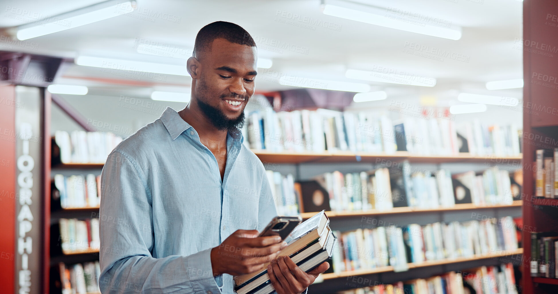Buy stock photo Happy, black man and student with phone in library for social media, reading chat and university app. Person, mobile and communication for learning, scholarship application and studying notification