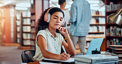 Buy stock photo Student, headphones and writing in library for university, woman and studying for education or project. Female person, notes and academy campus with literature, research and assignment for knowledge
