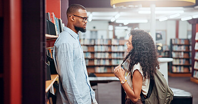 Buy stock photo Couple, talking or man with woman in library for dating, college education and chat on break. University, interracial and students flirting in campus for learning, relationship and studying together