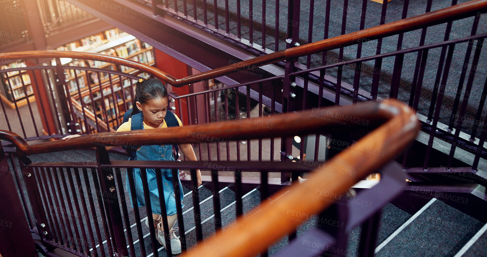 Buy stock photo Child, girl and stairs in library for education, student walking for learning and knowledge at academy campus. Scholarship, growth and development, story time in bookshop or literacy study at school
