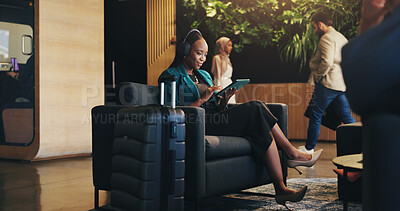 Buy stock photo Business woman, headphones and tablet in lobby for planning, research or travel for seminar. Chair, music or streaming with happy flight passenger in hotel with luggage or suitcase for job trip