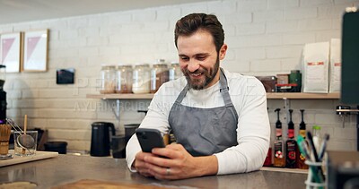Buy stock photo Happy man, barista and chatting with phone at cafe counter for small business, social media or review. Male person, bistro or employee with smile on mobile smartphone for online app at coffee shop