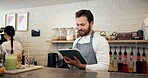 Smile, man and waiter on tablet at cafe for menu planning, online orders and inventory management. Male person, digital and website reviews, review stock and checklist update of hospitality industry