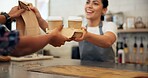 Happy woman, barista or customer with serving at cafe counter for parcel, drinks or purchase. Female person, bistro or smile with package or beverages for hospitality, order or service at coffee shop