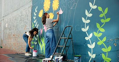 Buy stock photo Girls, outdoor or friends painting on wall for mural, drawing flowers or community service at building. Artist, creative or women with teamwork for floral decoration, renovation or project for design