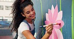 Painting, mural and woman with wall in city for art design, creative project and community service. Artist, volunteer and person with paintbrush outdoor for flower decor, inspiration and DIY hobby