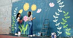 Girls, painters or teamwork for wall for mural, drawing flowers or community service at building. Artist, talking or creative women with craft for floral decoration, renovation or project for design