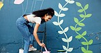 Woman, creative or painting on wall for mural, drawing flowers or community service at building. Artist, outdoor or girl with color for floral decoration, renovation or project for aesthetic design