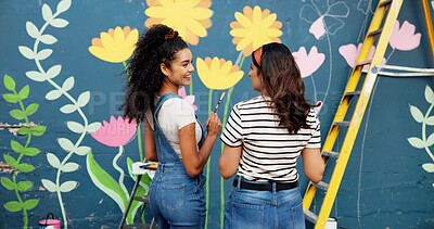 Buy stock photo Conversation, women and painting mural for wall, ladder or community project with artistic expression. People, outdoor or friends with creativity, volunteer or diy decor with flowers or student hobby