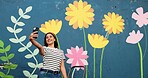 Selfie, painting and smile with woman and wall for flower mural, earth day promotion and eco artist. Sustainability project, environment activist and photography with person and biodegradable painter