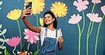 Selfie, painting and wall with woman in city for flower mural, earth day promotion and eco artist. Sustainability awareness, environment activist and photography with person and biodegradable painter