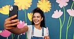Selfie, painting and happy with woman and wall for flower mural, earth day promotion and eco artist. Urban project, environment activist and photography with person and biodegradable painter
